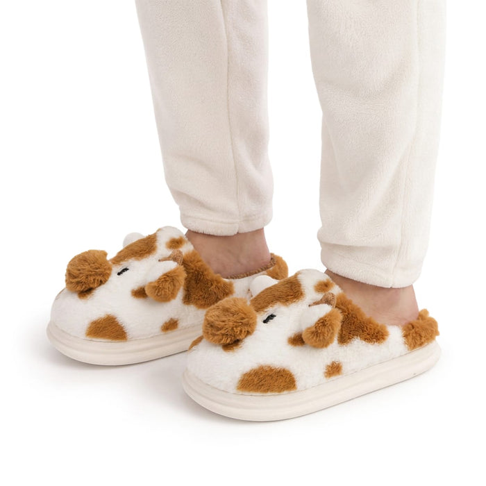 Henkilö vaaleissa pyjamoissa, jaloissa pehmeät lehmäkuvioiset sisätossut, joiden pohjassa on liukueste.